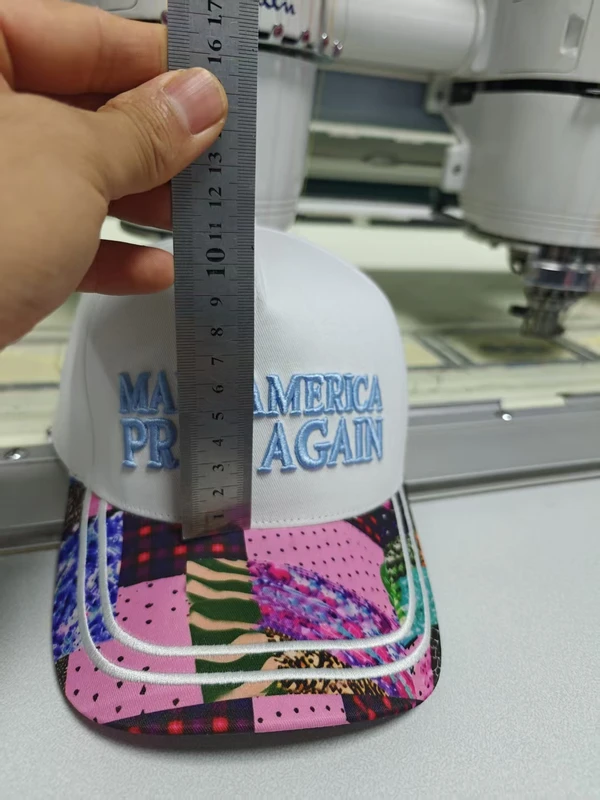 Metal ruler held against the front crown of a white baseball cap to discuss front panel height