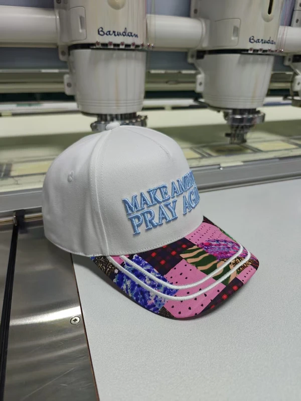 Three-quarter view of a white-crown baseball cap with colourful patterned visor and two white curved decorative lines