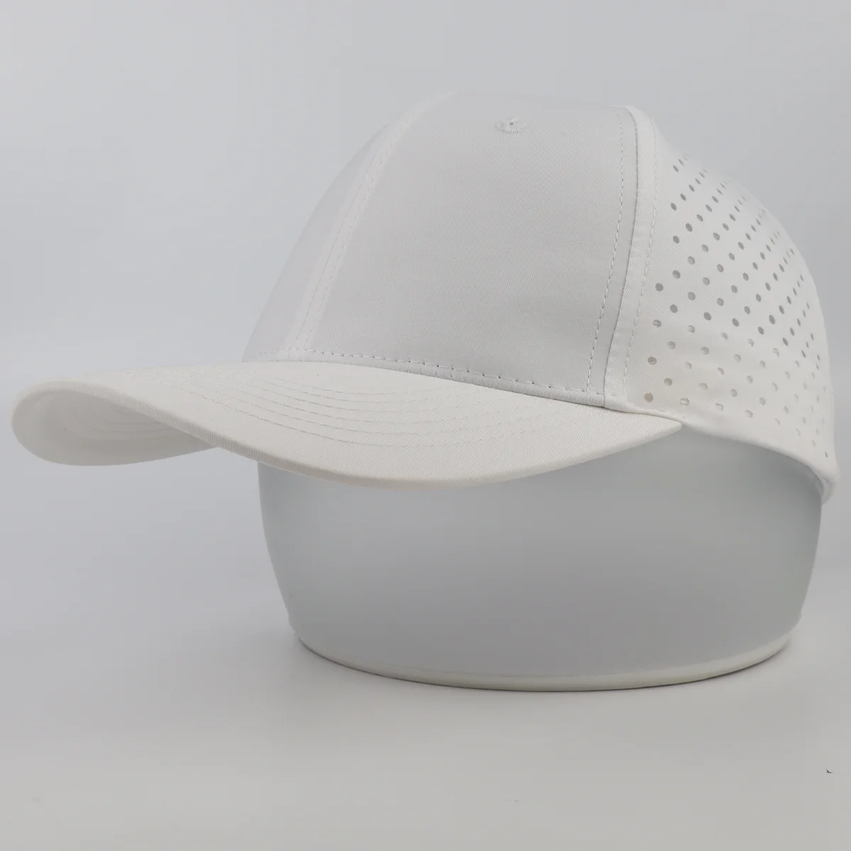 White curved-brim cap with solid front panels and perforated side crown
