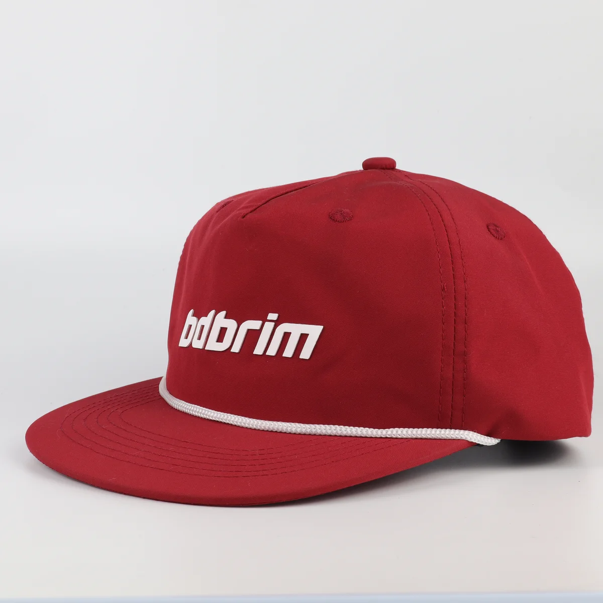 Alternate view of red golf cap with white rope trim on visor