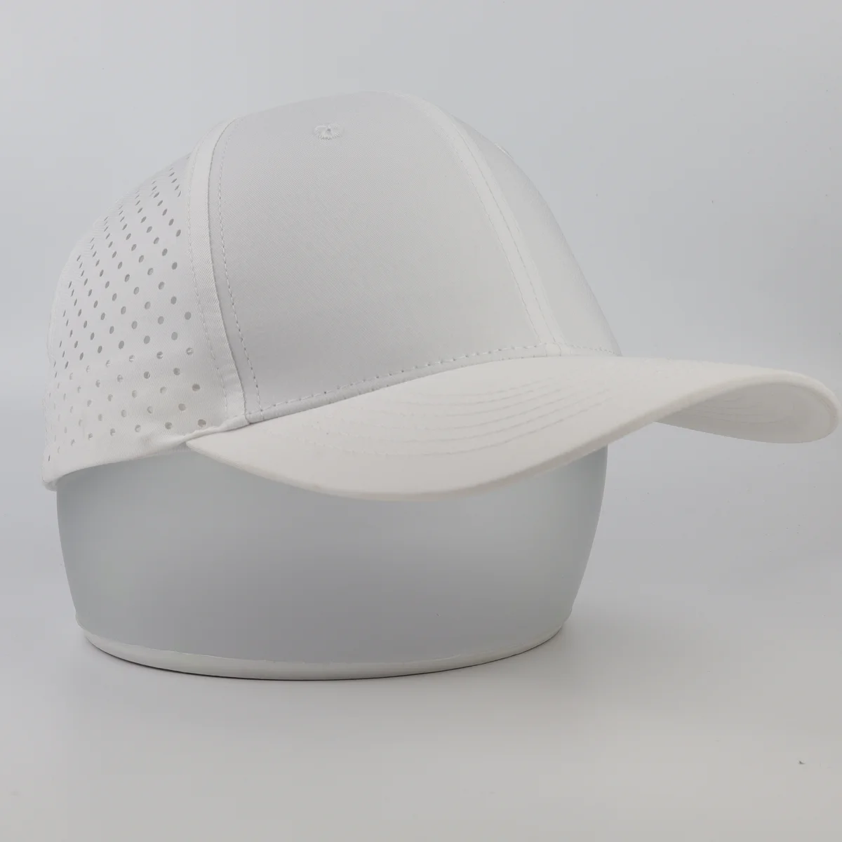 White technical cap with perforated back panels and curved visor